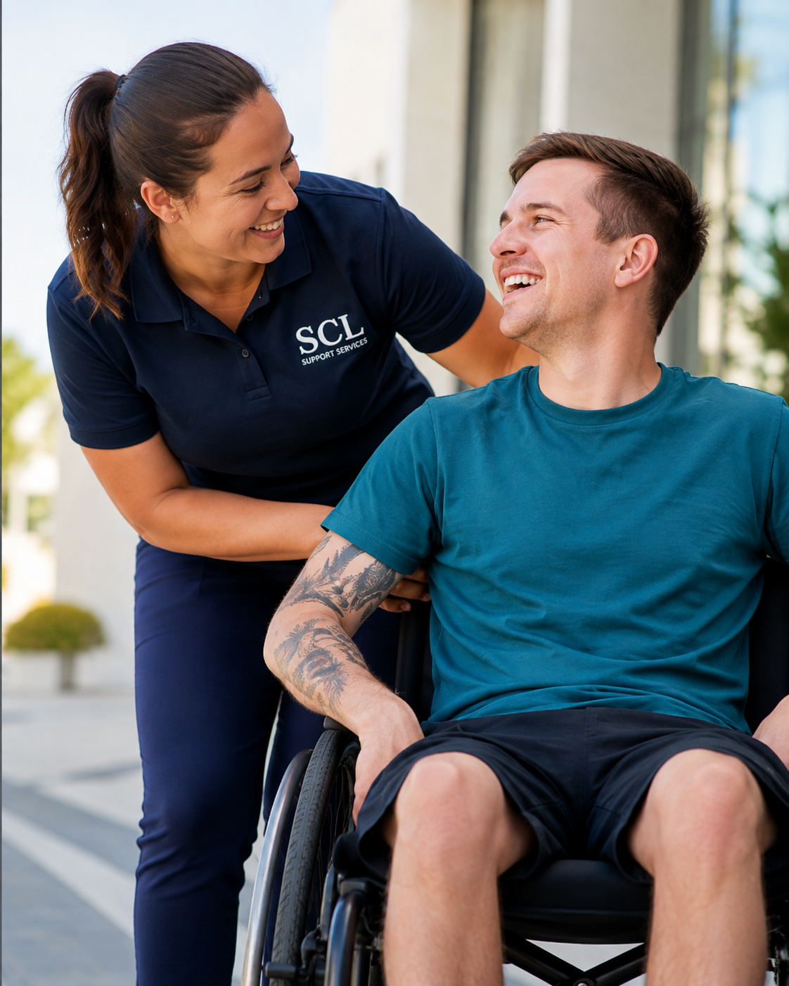 An SCL Support Services worker with a participant using a wheelchair outdoors